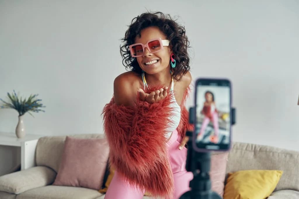 Créatrice qui enregistre un carrousel, bisou vers la caméra, salon lumineux, trépied